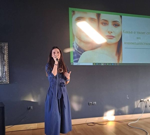 Елина Божимирова говори с микрофон пред слайд за стила на взаимодействие